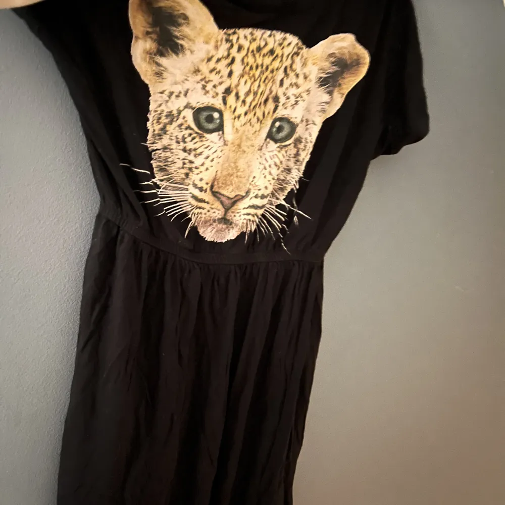 Cool svart barn klänning med leopard tryck från H&M. Storlek 8-10y. Plagget levereras tvättat och strykt. Kontakta mig vid mer information . Klänningar.