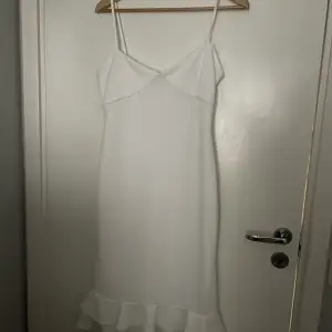 En vit klänning från boohoo som aldrig använts. Den går till knäna 
