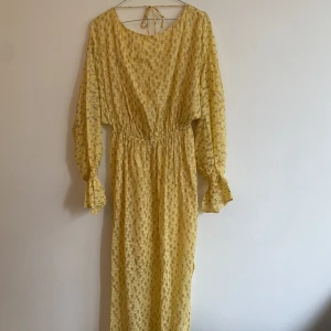 Klänning - Glittrig ljusgul klänning med öppen rygg från Baum und pferdgarten. Inköpt för 4.700kr och aldrig använd pga inställd bal :) Lappen sitter kvar 🧡  Storlek 34 men stretchig och sitter löst så passa större än så också!