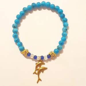 Vackert blått armband med delfun berlock. Ger en sommarkänsla av hav och klarblå himmel. Mycket fint som present eller något du själv kan unna dig med!