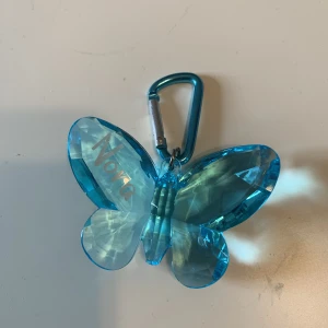 Nyckelknippa  - Blå nyckelknippa som ser ut som en fjäril! På ena vingen står det ”Nora”. Frakt tillkommer 