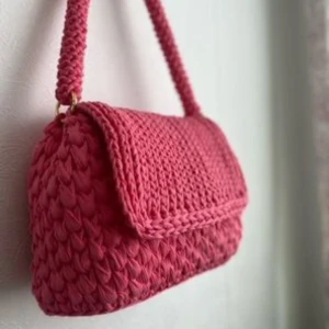 Virkad väska - Helt nyvirkad väska i rosa. Sista bilden visar färger på lås som finns. Osynlig magnetknapp kan sys in om man vill. Väskfötter i roséguld och svart/silver finns oxå. Mått: längd: 24cm, djup:9cm, höjd:16,5., handtag: 55cm Frakt: 69:- postnord spårbart