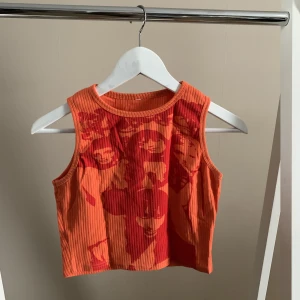 Linne med tryck - Oranget ribbat linne med tryck. Strl s, knappt använt. 50kr+frakt