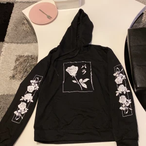 Svart hoodie med tryck - En jätteskön hoodie i tunnare variant. Har blommor på framsidan och på ärmarna. Köparen står för frakten ❤️
