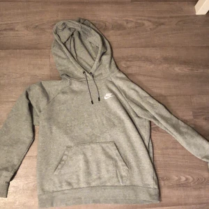 Grå Nike hoodie - Säljer en fin och knappt använd Nike hoodie i storlek medium. Säljs då den inte kommer till användning.  Hör av er vid funderingar eller köp! 😊