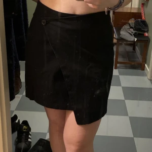 Svart kjol - Kjol från Monki. Går omlott och stängs med knapp. Aldrig använd. Bra kvalite, och bekväm! Skriv privat för fler bilder/frågor! Kan mötas upp i Malmö annars står köparen för frakten💕