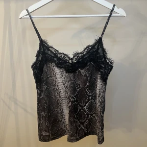 Ormmönstrat linne från Zara - Superfint ormmönstrat linne med svart spets från Zara i storlek S. Fint använt skick!