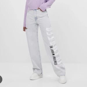 Jeans - Slutsålda Bershka jeans uv react. Texten är vit men blir lila i direkt solljus (se min bild). Kan skicka fler egna bilder vid intresse. 