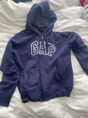 Marinblå Gap Hoodie  - Marinblå Gap Hoodie - säljer för att den passar inte, sitter tight och är smal (L I barn storlek). Tror att den är XS-S i vanlig storlek. 