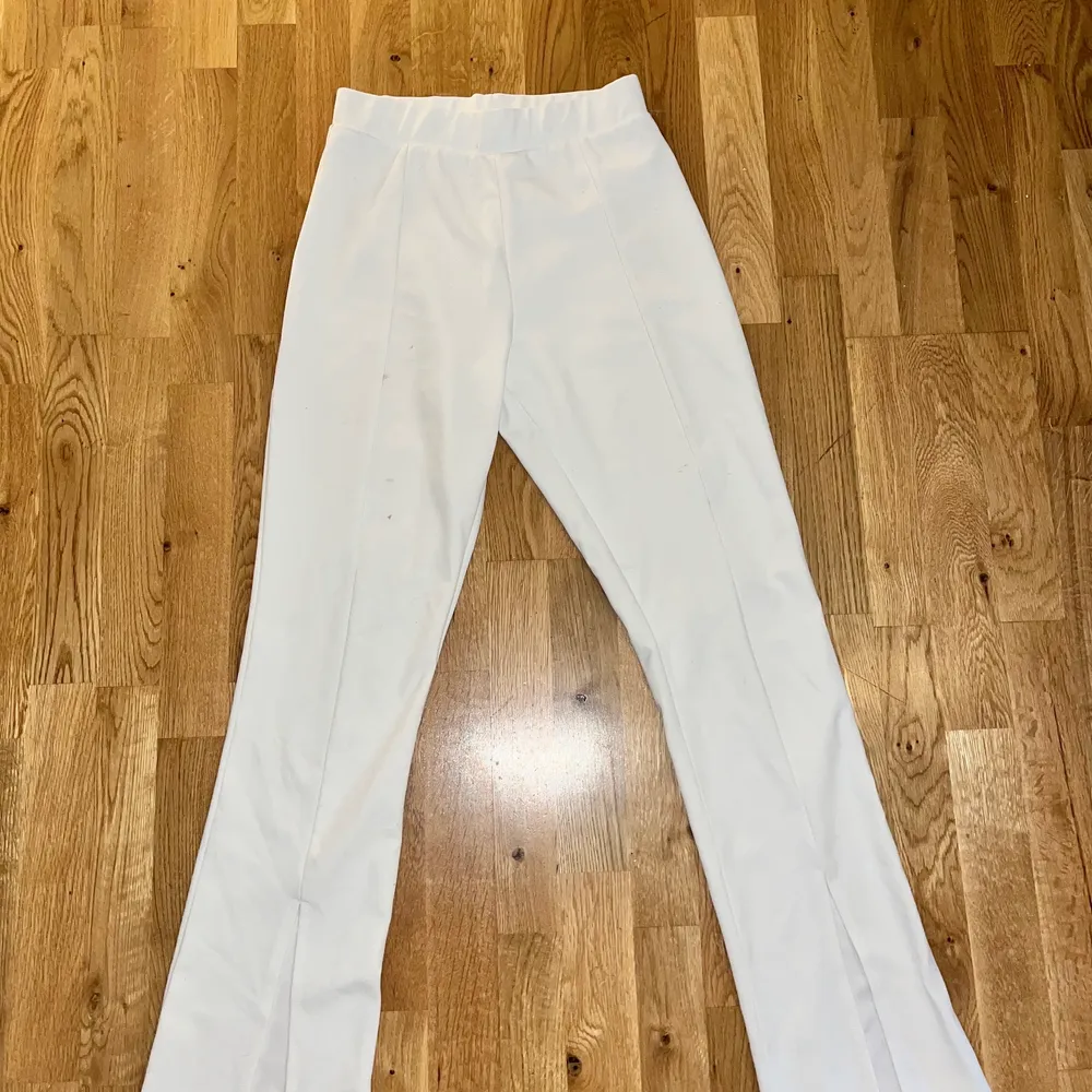 Säljer dessa snygga vita kostymbyxor från Nelly med slits därframme på ankeln. Något slitna i storlek S. Jeans & Byxor.