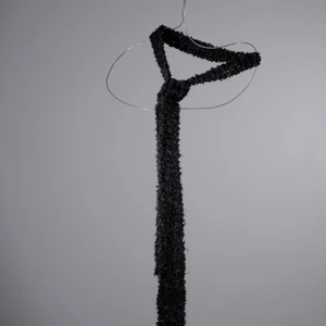 Stickad mörkgrå slips - One-of-a-kind stickad slips i mörkgrått. Stickad av Röda Korsets-stickgrupp i Västerort tillsammans med Ebba Martin. Alla pengar från budgivningen går oavkortat till Röda Korsets arbete för att hjälpa människor i kris och katastrofer.