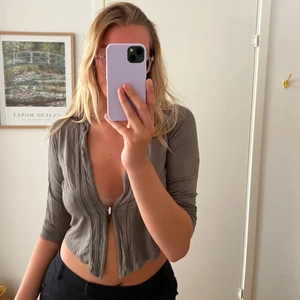 Grå topp - Snygg grå topp som går att ha för sig själv eller med en annan tröja under. Har spänne där fram och sitter lite större på mig så beroende på hur man vill att den ska sitta passar den flera storlekar. Jag är en S/M. Ja 