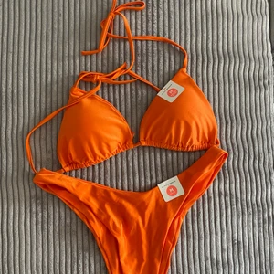 Orange bikini  - Orange bikini från Bik Bok, storlek M! Helt oanvänd med alla lappar kvar. Tyget är nästan lite skimrande, se sista bilden. ✨✨✨