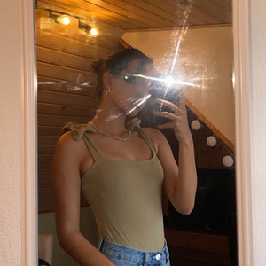 Grön topp med knytning - Super fin grön topp med knytband på axlarna, bra skick 