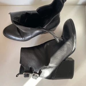 Läder stövletter  - • Edgy stövletter i läder • Använda, i bra skick! Flera foton kan skickast ved förfrågan. Har två stycken metallspännor på sidan, skorna är i läder och bra kvalitet.