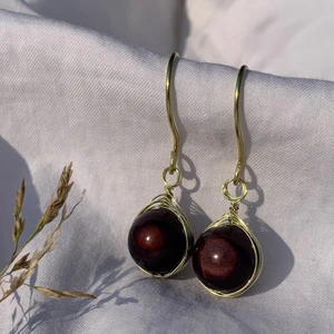 Guld örhängen - Handgjorda örhängen med mörkbruna pärlor, och guldpläterad koppartråd. Nickel-, kadium-, och blyfria. 2x1,5cm