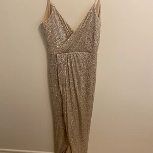 Glittrig balklänning  - En glittrig champagnefärgad balklänning. Klänningen är V ringad och öppen i ryggen. Fram har den en slits och är superfin. Använd en gång.❤️ köpt för 1100kr