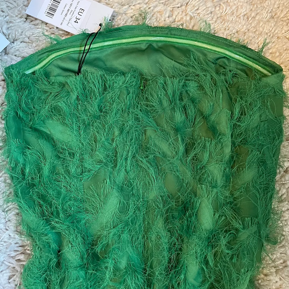 Säljer denna gröna tubklänning med faux fjädrar från NA-KD. Aldrig använd och lapparna sitter kvar. Säljer då jag inte tycker att den passar mig. Kan mötas i sthlm eller Västerås. Vid frakt tillkommer fraktkostnad😊💕. Klänningar.