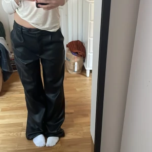 Fejk läderbyxor  - Säljer mina lågmidjade låtsats läder byxor som är perfekt till fest! Säljer då de är för långa för mig som är 163 cm (har korta ben) De har använts några gånger men är i bra skick! Köpta för ca 600 kr på NA-KD för något år sen. Köparen står för frakt 💕