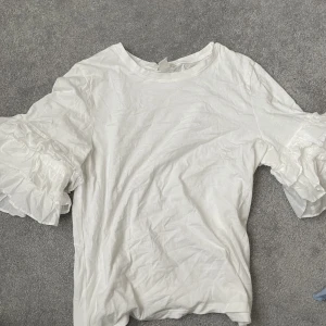 Vit t-shirt - Vit t-shirt med volang ärmar 
