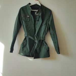 Jacka  - Snygg vårjacka från Elvine. Militärgrön använt få gånger. Saknas en knapp. Strl M men sitter bra för både en person med strl M & S.