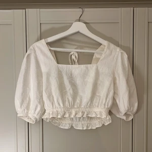 Somrig topp - Jag säljer denna somriga toppen som är så fin i ryggen💗Den är i storlek 36 och kommer ifrån NA-KD💗Den är 10/10 i skick!