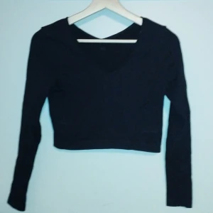 V ringad träningstopp - Ribbad i maglängd  Fin svart färg som inte gjorde sin rättvisa med blixten på 