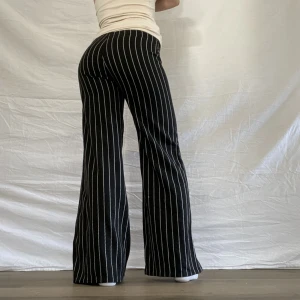  lågmidjade byxor - Lågmidjade vida byxor med vita ränder! Midjemått 82 innebenslängd 75 cm