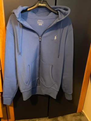En ljusblå polo hoodie som är i bra skick med storlek xs priset kan diskuteras 