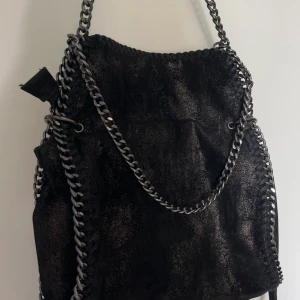 Svart handväska  - Säljer nu min Stella Mcartnty insperarade väska på grund av kommer inte till användning💔 ”Glittret” har kommit av på vissa delar av väskan annars är det inget fel på den💗 