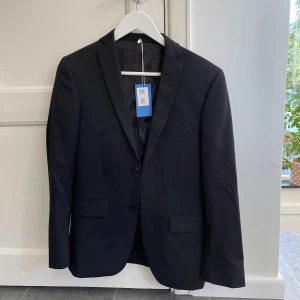 Svart kavaj - En svart kavaj i herrstorlek 44 från dressman. Den är i mycket bra skicka och passar mig som är 162 cm. Den har både fickor på in- och utsidan.