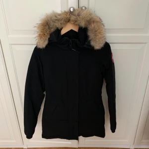Canada Goose Victoria parka vinterjacka äkta päls - Säljer min fina Canada Goose jacka, Victoria parka, i stl XS. Den har använts i 2 vintrar och därav fått lite slitage på ärmarna men annars är den i jättefint skick. Sparsamt använd. Den har en pälskrage i äkta varg päls. Kvitto finns.