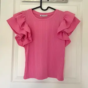 Säljer denna rosa volang tröjan från Zara i stl S, aldrig använd utan enbart testad. Dock har lappen på ena sidan gått upp (se tredje bild) men så var den när jag köpte den💓 150kr+51kr spårbar frakt