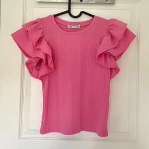 Volang tröja - Säljer denna rosa volang tröjan från Zara i stl S, aldrig använd utan enbart testad. Dock har lappen på ena sidan gått upp (se tredje bild) men så var den när jag köpte den💓 150kr+51kr spårbar frakt