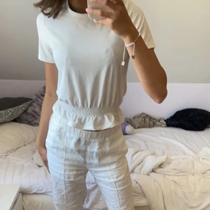 Vit topp med volang  - Fin topp med volang längst ner från Gina tricot.  Köpt för nått år sen för 199kr. Lite ribbad (se bild 2). Säljs för 80kr