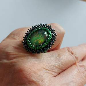Egen designad av mig Stenen är en tjeckisk smyckesten infattad av små pärlor miyuki seed beeds och miyuki delica  Själva smycket är 2,8×2,4cm Ringen är storl 16 De svarta små pärlorna är av hematit Frakt 13kr