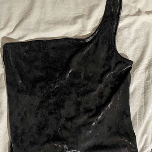 One shoulder topp - En jättesnygg one shoulder topp som aldrig är använd. Är för stor. Inga hål eller fläckar. Är i krossad plysch tyg. Läs min bio innan du köper💗