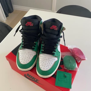 Nike Air Jordan 1 Retro High Lucky Green - Säljer nu mina ca 1,5 år gamla Air Jordan 1 Retro High Lucky Green i storlek 38. Använt sparsamt och är i mycket fint skick. Köpta på Selfridges i London. Gröna och vita med svarta snören men finns även gröna och röda!  Unisex!