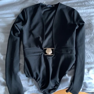 Svart Body med spänne  - Svart body från pretty little thing 