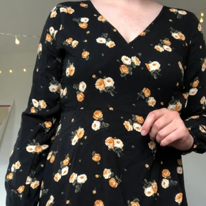 Hollister svart klänning storlek M - Svart långärmad klänning i storlek M med gult blommigt mönster på, inköpt på Hollister. Perfekt till sommaren! Mjuk och skön att ha på sig, kan knytas med band i midjan