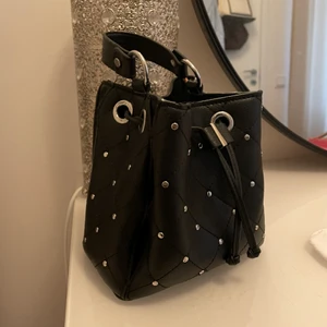 Väska med nitar - Hej, säljer min älskade väska med nitar från zara. Den är använd men är fortfarande u mycket bra skick. Den är rymlig och det tillkommer även ett axelremsband till väskan. Hör av dig om du är intresserad😊