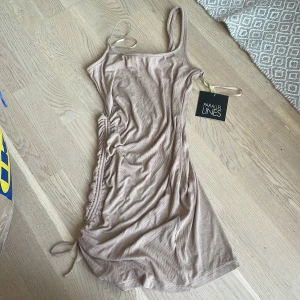 OANVÄND BRUN/BEIGE KLÄNNING - Tight, kan göras kort och längre i längd, en-axel. Brun/beige. 