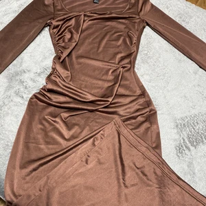 Brun lång klänning i strl xs - Brun satin klänning i strl xs, köpt från shein men inte använt, bra material. Ganska lång men beror på hur lång du är. Jättefin och ganska basic men den är unik med färgen och sitter jättefin på kroppen.💞