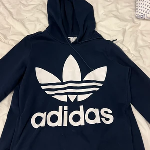 Adidas Hoodie - Fin marinblå hoodie från adidas. Med gamla adidasmärket. Aldrig använd. Passar alla från S-L beroende på hur man vill att den ska sitta. 