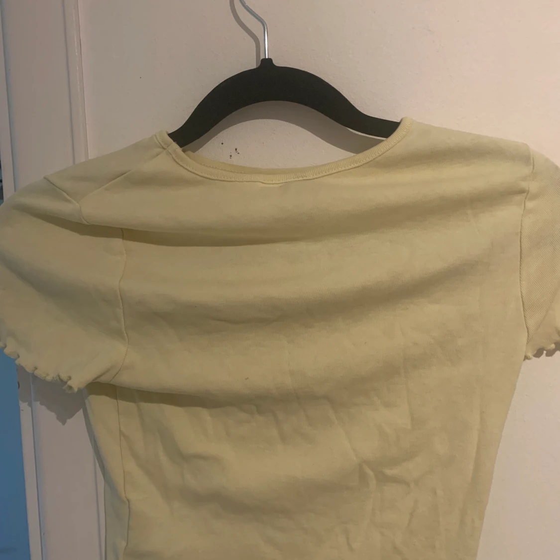 Jag säljer en gul topp med en fin sol på framsidan. - 90