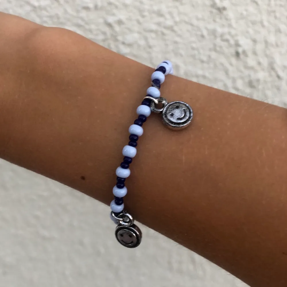 Ett super snyggt armband i blåa färger, samt med silver berlocker som har smiley face på sig. Du kan bestämma längden själv på ditt armband. FRAKT INGÅR!😊 ( strunta i det som det står i levarnas alternativ)💞💕. Accessoarer.