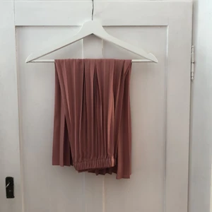 Plisserad långkjol - Plisserad långkjol från Ginatricot i en fin gammelrosa färg! Superfint skick, endast använd 2-3 gånger. Frakt på 66kr tillkommer. 