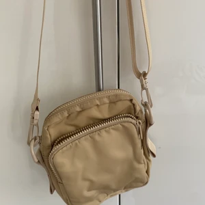 Väska - Liten beige smidig väska med långt axelband. Säljer den då den knappt kommit till någon användning💗