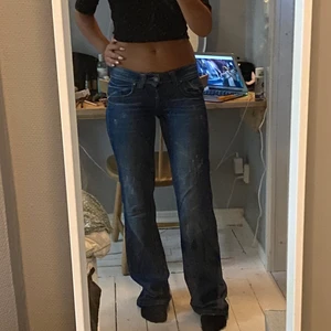 Lågmidjade utsvängda jeans - Ett par mörkblåa lågmidjade jeans från Gina Tricot som är så sjukt snygga men tyvärr blivit en aning tajta på mig som vanligtvis har storlek 27 i midjan. De är för långa på mig som är 165 och passar nog någon som är 165-178. 
