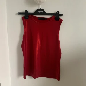 Röd topp - (Inga bilder på. Tryck inte på köp direkt) Röd glittrig/shiny topp från Kappahl i storlek 38-40❤️som ny!  Fraktkostnaden kan variera beroende på betalsätt💞